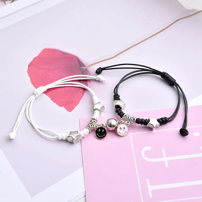 A pair of magnet couple bracelets with a suction clasp, showing various design options like clovers, crowns, and hearts.