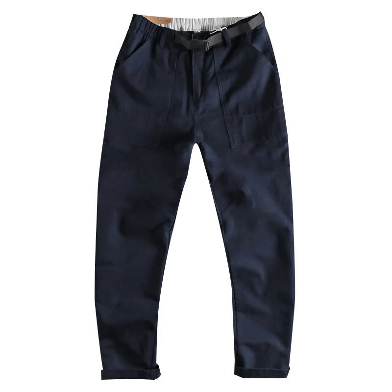 Men's khaki work trousers with a three-dimensional cut and an N I buckle belt on a hanger.