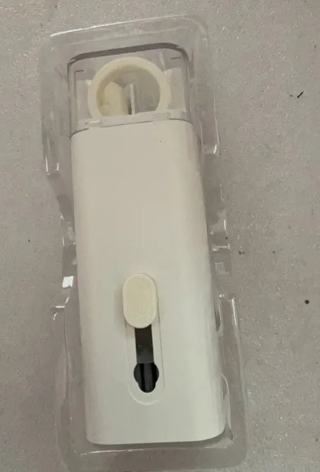 White electronics cleaning kit with a cleaning pen, spray bottle, brush, and keycap puller on a table