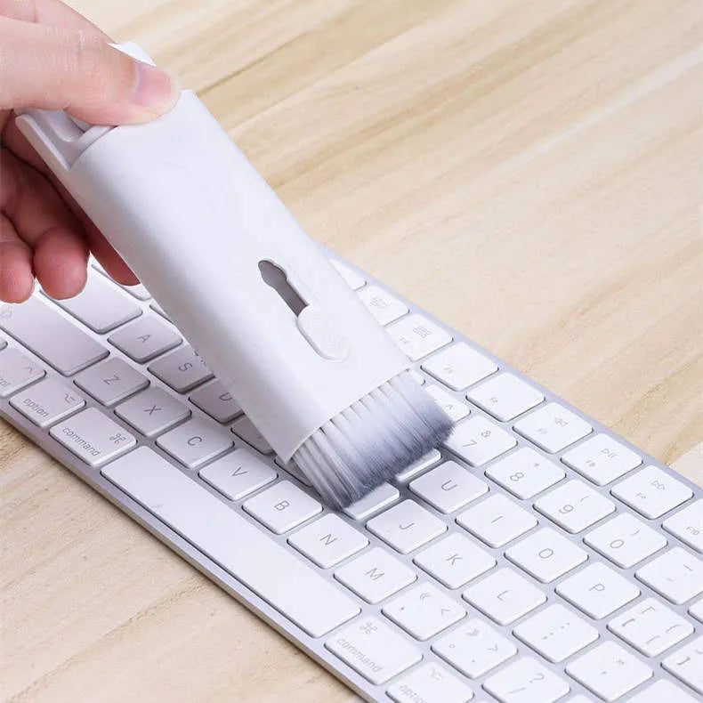White electronics cleaning kit with a cleaning pen, spray bottle, brush, and keycap puller on a table