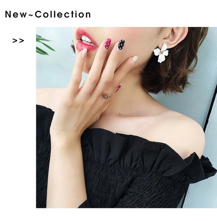 A pair of women's flower-shaped alloy stud earrings with a white electroplated finish.