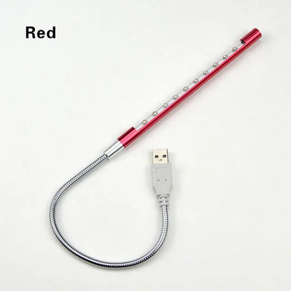 Spiral shaped silver aluminium USB LED desk lamp bent on a wooden desk.