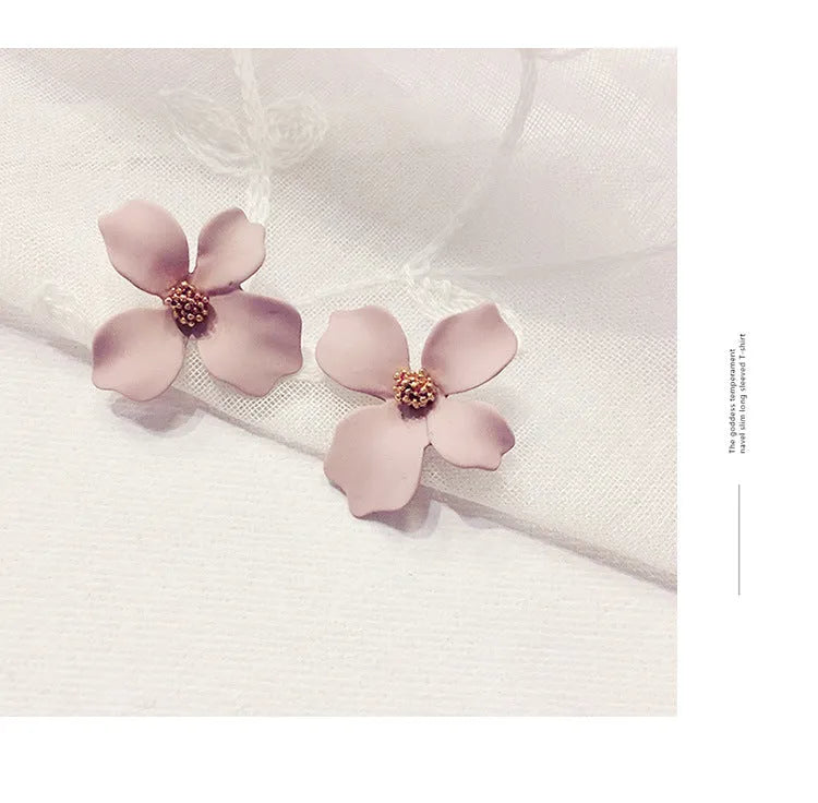 A pair of women's flower-shaped alloy stud earrings with a white electroplated finish.