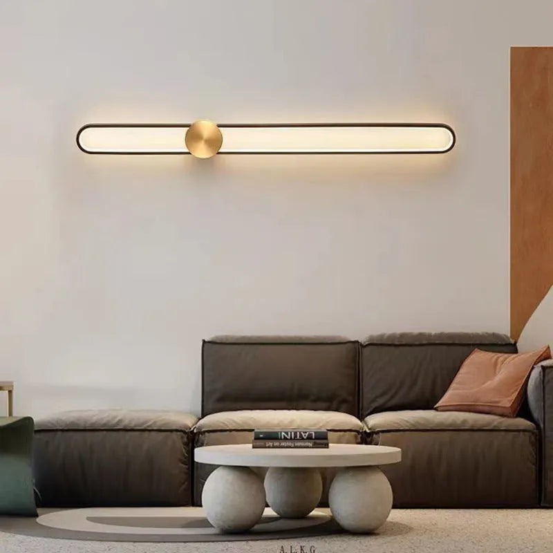Modern round wall lamp with black iron shade and warm LED light, mounted on a grey wall.