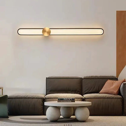 Modern round wall lamp with black iron shade and warm LED light, mounted on a grey wall.