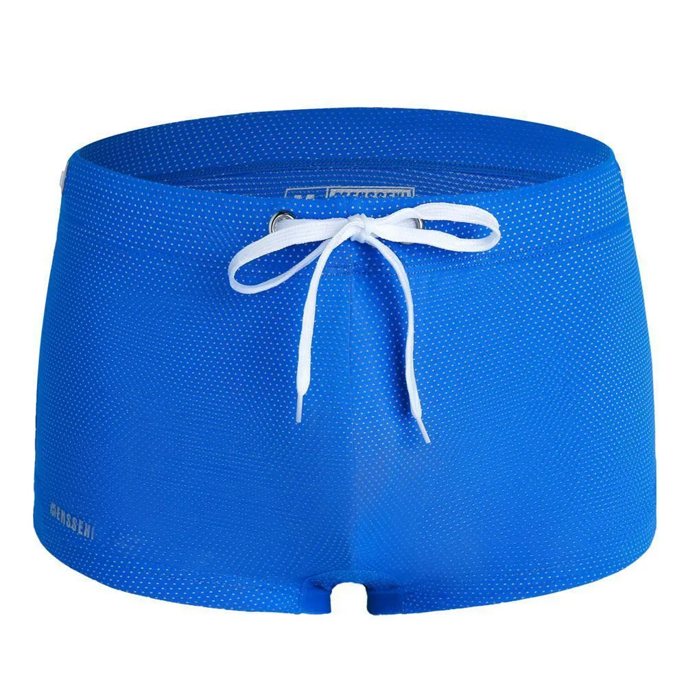 Men's low waist swim trunks in stretch nylon on a man, showing elastic waistband and boxer-style cut.