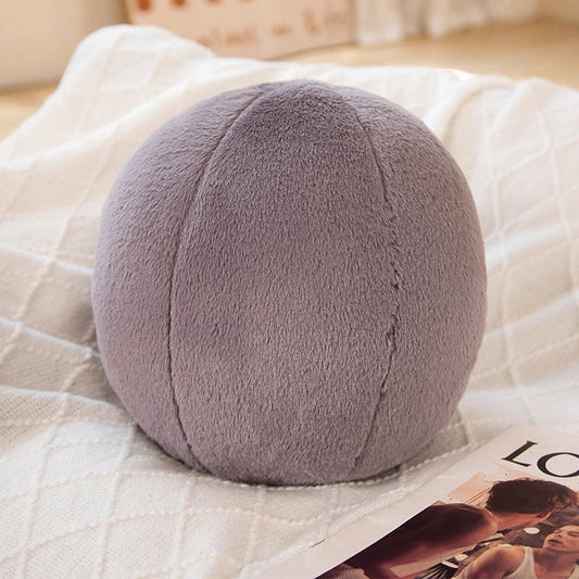 A soft, grey plush toy pillow with a round, furry design that adds a cosy and whimsical touch to home decor.