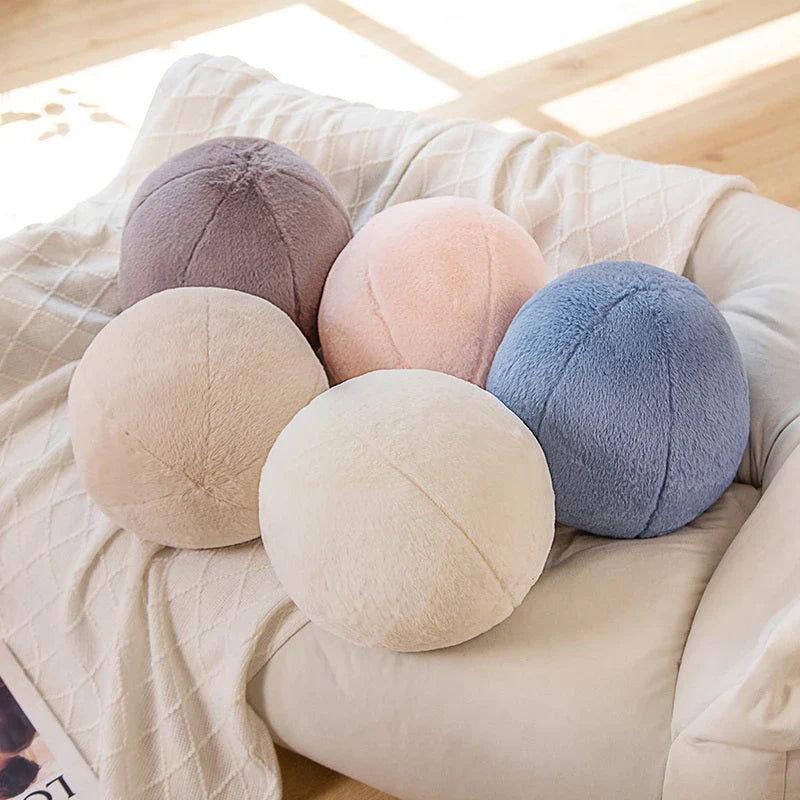 A soft, grey plush toy pillow with a round, furry design that adds a cosy and whimsical touch to home decor.