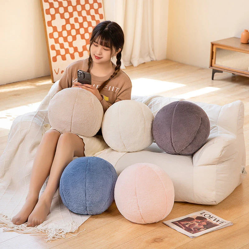 A soft, grey plush toy pillow with a round, furry design that adds a cosy and whimsical touch to home decor.