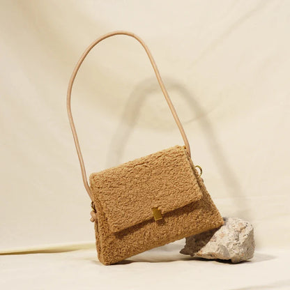 A stylish faux lamb wool crossbody bag in a neutral colour, featuring a double strap design and multiple interior compartments for organised storage.