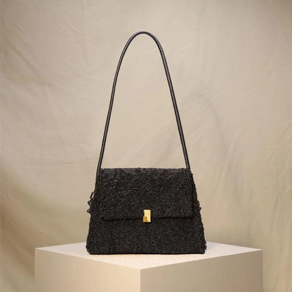 A stylish faux lamb wool crossbody bag in a neutral colour, featuring a double strap design and multiple interior compartments for organised storage.
