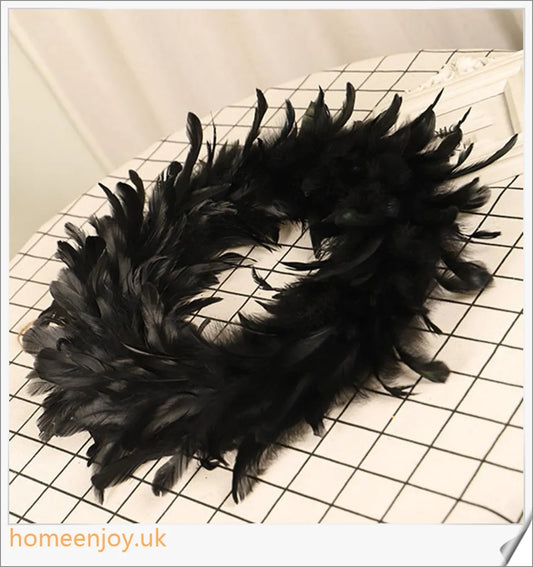 Black Halloween wreath made of luxurious natural feathers in shades of onyx, green, and purple