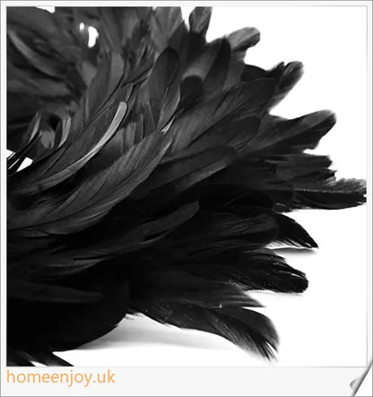 Black Halloween wreath made of luxurious natural feathers in shades of onyx, green, and purple