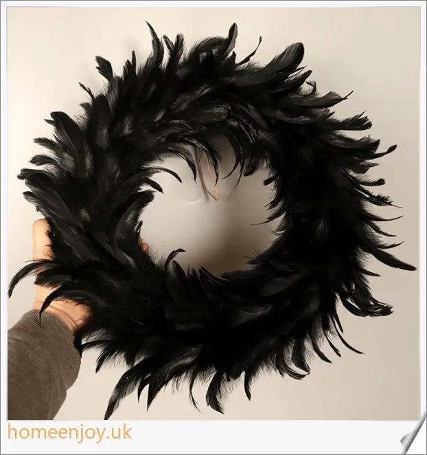 Black Halloween wreath made of luxurious natural feathers in shades of onyx, green, and purple
