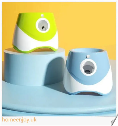Automatic dog ball launcher toy in blue colour, with three tennis balls and a charging cable