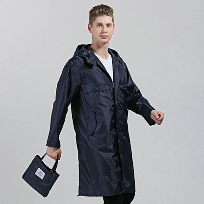 A man wearing a navy blue waterproof nylon raincoat standing in a field