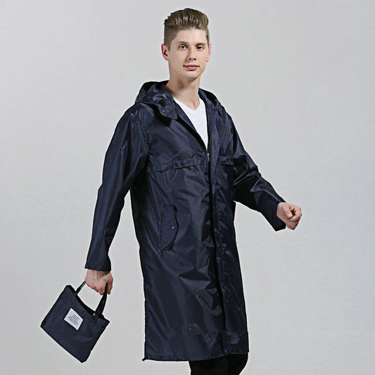 A man wearing a navy blue waterproof nylon raincoat standing in a field