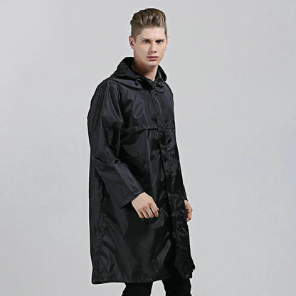 A man wearing a navy blue waterproof nylon raincoat standing in a field