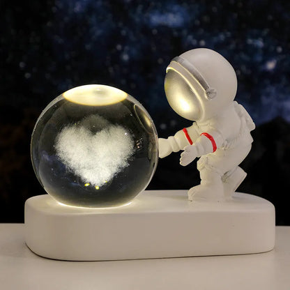 Glowing astronaut crystal ball night light with 6cm diameter and USB cable on wooden surface