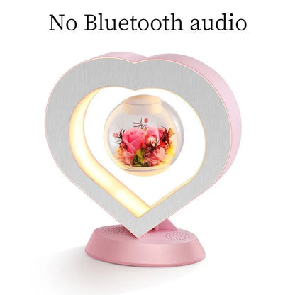 Pink rose eternal flower floating in magnetic levitation LED night light with triangular base and touch control