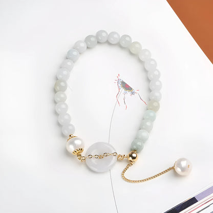 Natural jade bracelet with a geometric peace buckle clasp and round pendant.