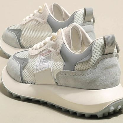 Women's grey low-top retro sneakers with mesh lining and round toe on a flat rubber sole.