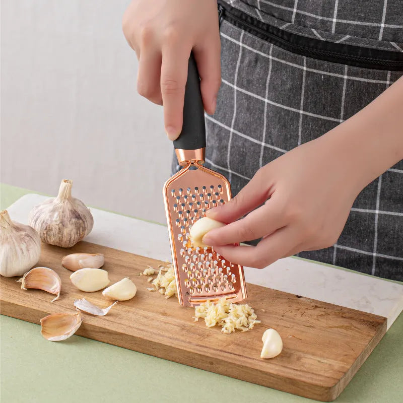 7-piece stainless steel kitchen tool set with copper finish on a countertop storage rack.