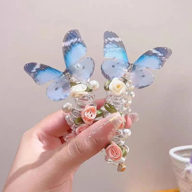 Colourful butterfly and pearl elastic hair band for children on a white background.