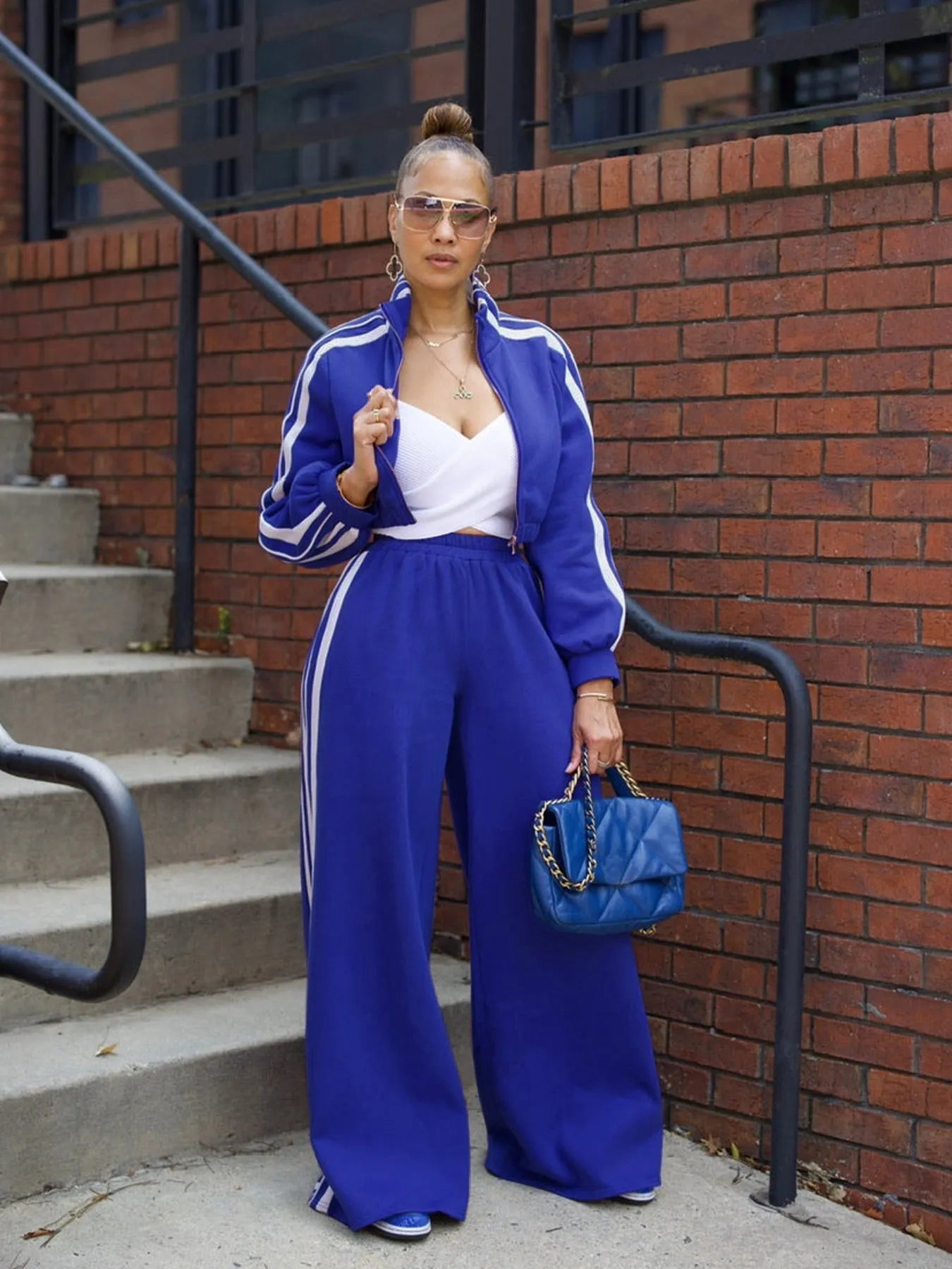 Woman wearing a grey striped zipper sweater and matching trousers from a casual two-piece set.
