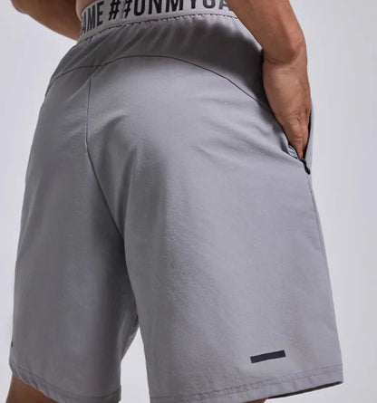 Men's loose black sports shorts with elastic waist and letter detail, shown front and back.