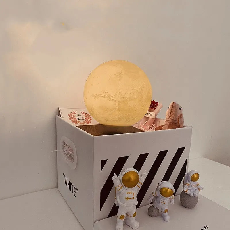 Maglev floating moon planet atmosphere night light with three astronaut figurines on a desk.