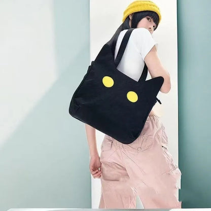 Black cat-shaped nylon tote bag with medium-soft structure, nylon lining, and sandwich zipper pocket, 34cm x 13cm x 27cm.