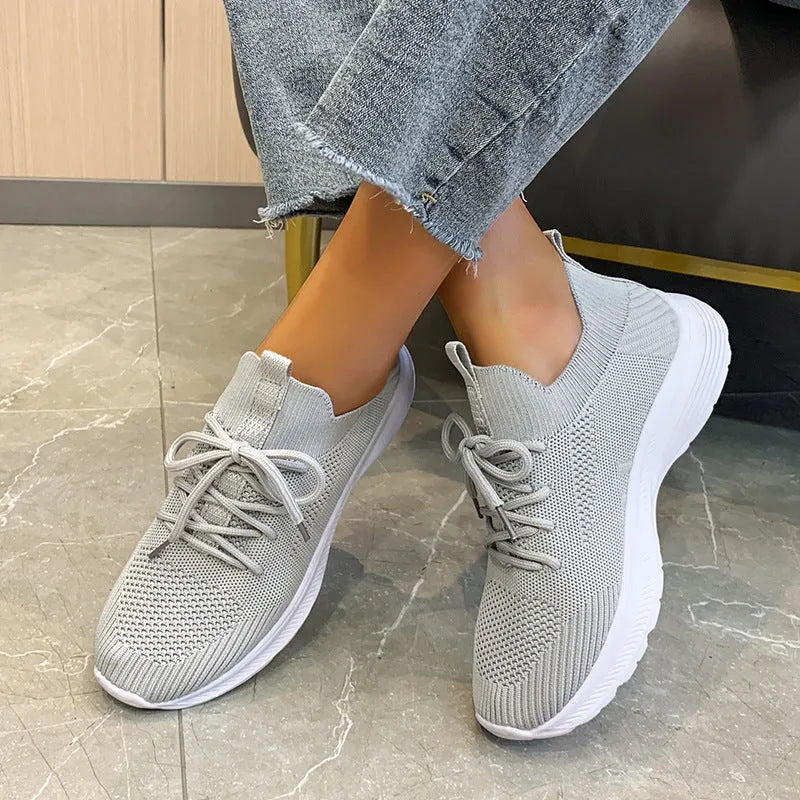 Women's Flyknit mesh running shoes in milky white with a low flat heel and rubber sole