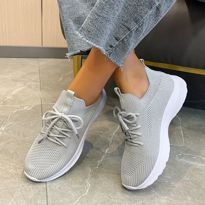 Women's Flyknit mesh running shoes in milky white with a low flat heel and rubber sole