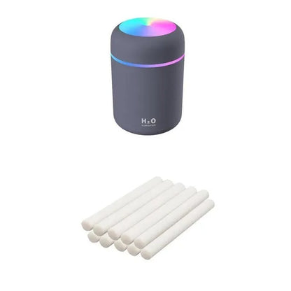Pink USB desktop humidifier with LED lights and water tank on wooden desk