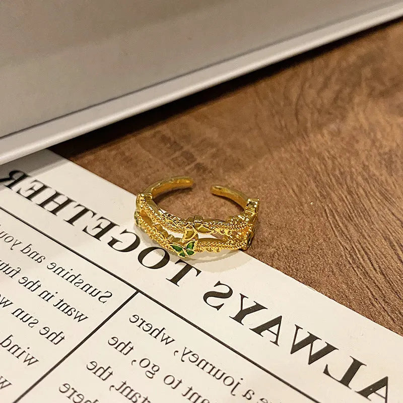 Copper butterfly women's ring with an open loop design on a plain background.