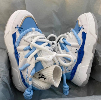 Women's grey thick-soled retro sneakers with lace-up front and chunky rubber platform sole on a wooden floor.