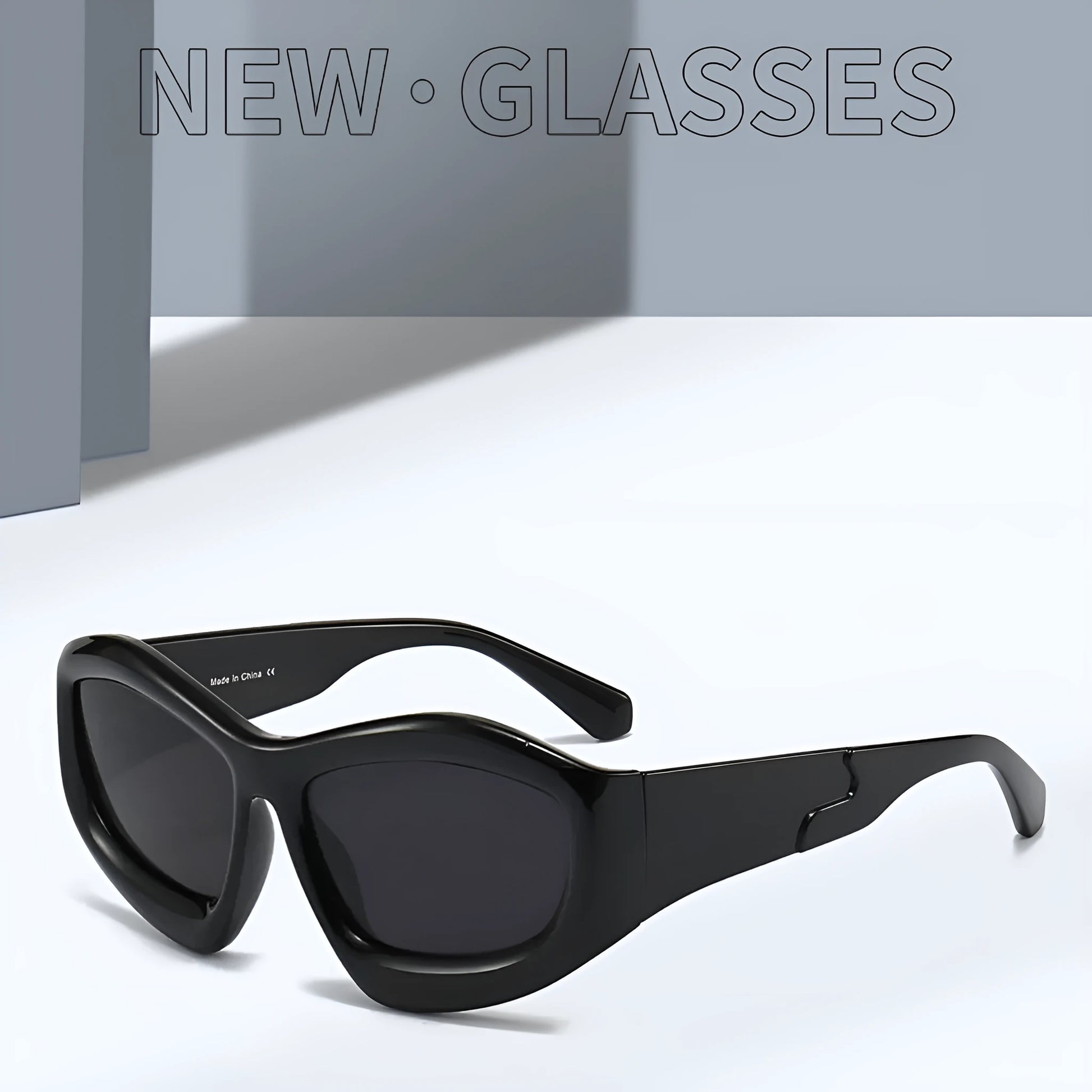 Outdoor unisex sunglasses with concave bubble lenses in black frame on a table.