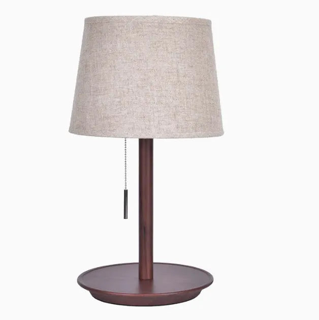 Walnut coloured solid wood bedside lamp with white fabric shade and cable switch.
