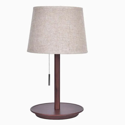 Walnut coloured solid wood bedside lamp with white fabric shade and cable switch.