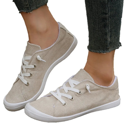 Women's creamy white low-top casual sneaker with fabric upper and rubber sole.