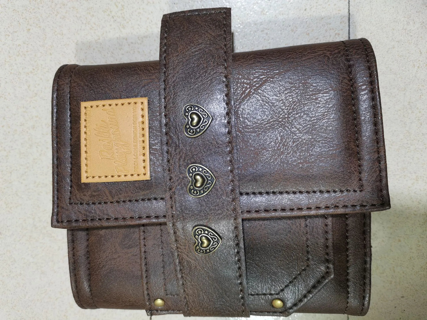 Brown A7 loose-leaf notebook with PU cover and retro buckle design, shown open.