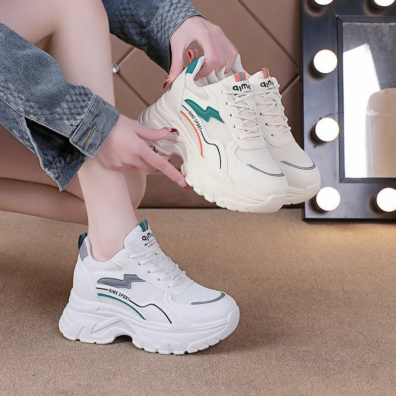 White women's dad sports trainers with cross straps and a lace-up front on a rubber sole.