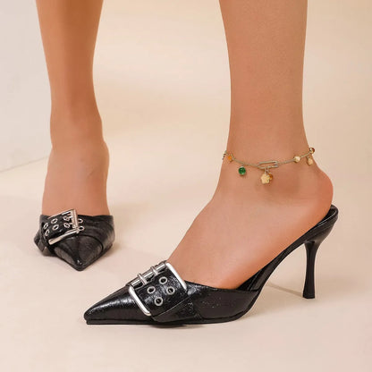 Black women's high heels with pointed toe, ankle strap, and decorative buckle.