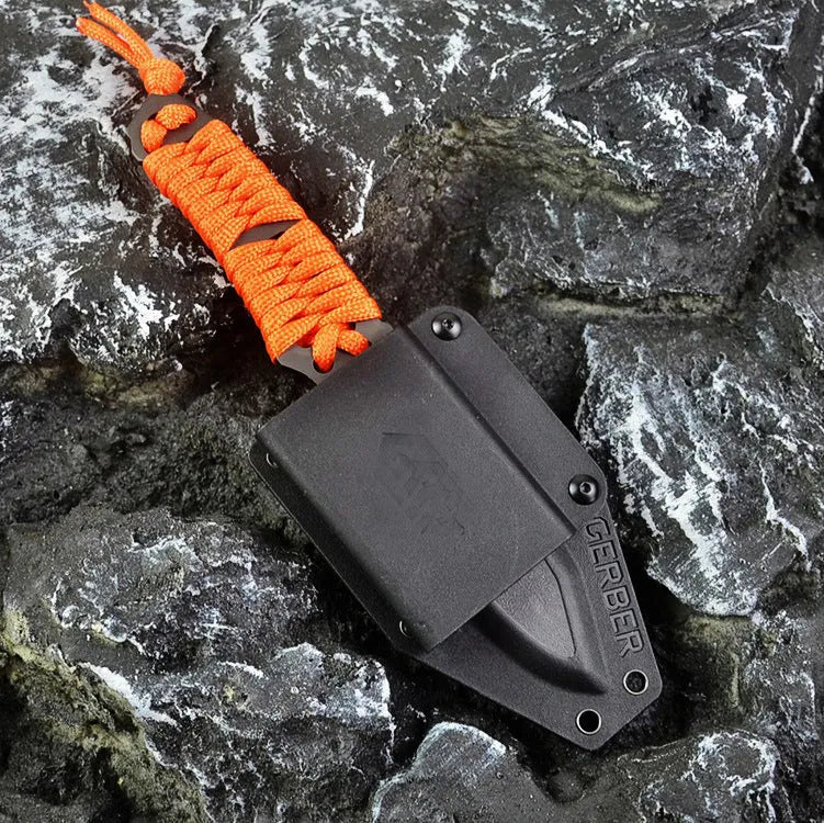Straight-blade survival knife with a binding rope handle next to its black ABS plastic sheath.