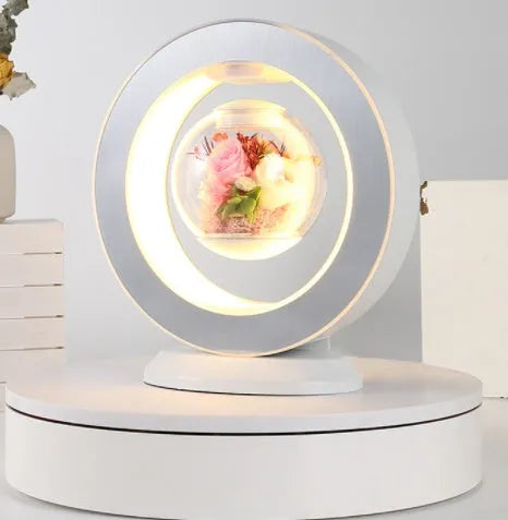 Pink rose eternal flower floating in magnetic levitation LED night light with triangular base and touch control