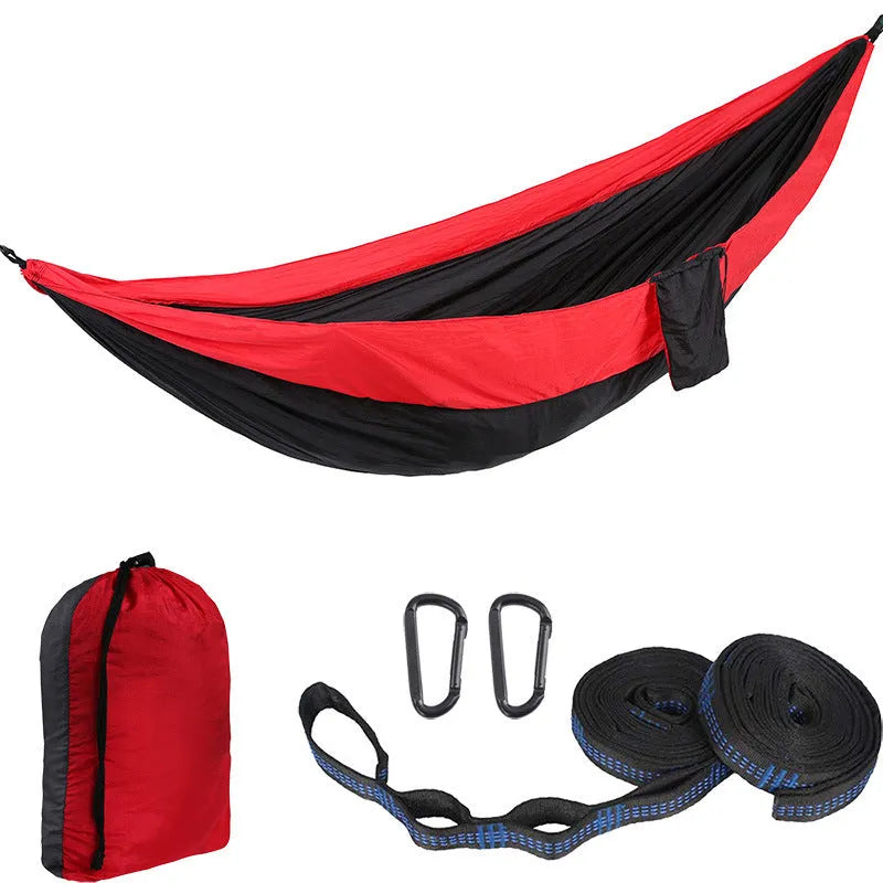 Parachute cloth double camping hammock in chosen colour, with black buckles and round ropes on a tree.