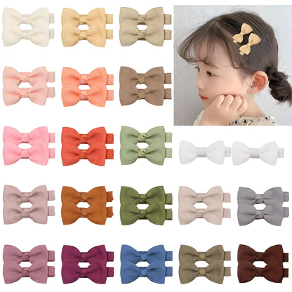 Assortment of pastel-coloured baby hair clips and bows with no-slip grips on a white background.