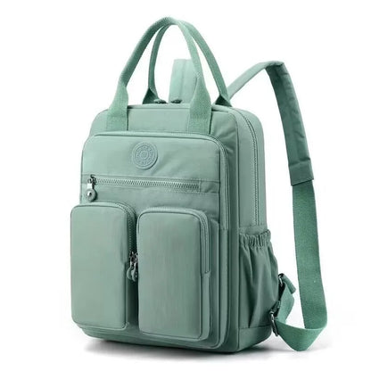 Women's waterproof nylon travel backpack in grey, showing front external pocket and organisational interior.