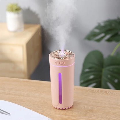 Black portable humidifier with LED lights beside car cup holder showing mist output